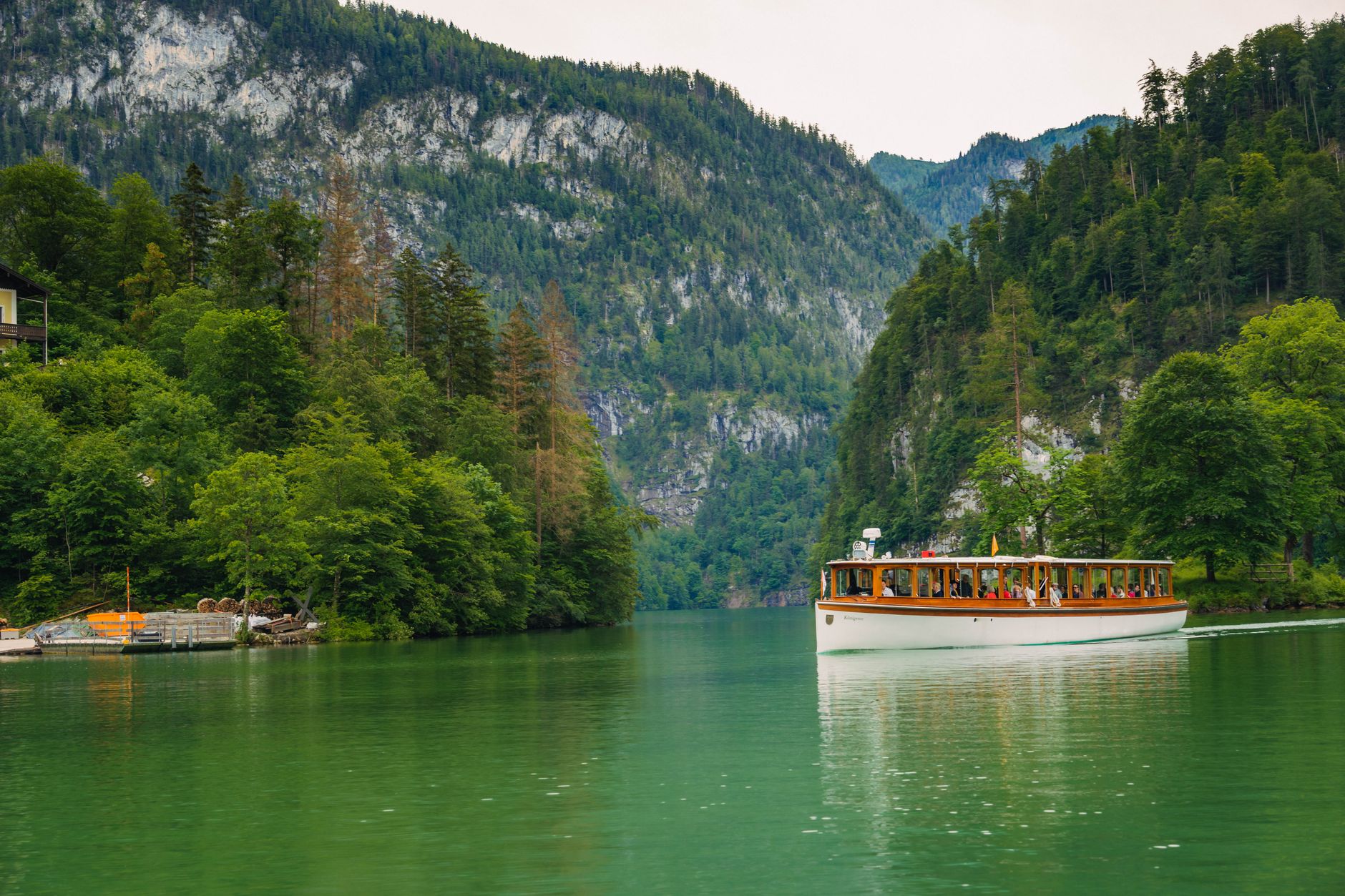Türkisfarbener Bergsee zwischen bewaldeten Hängen