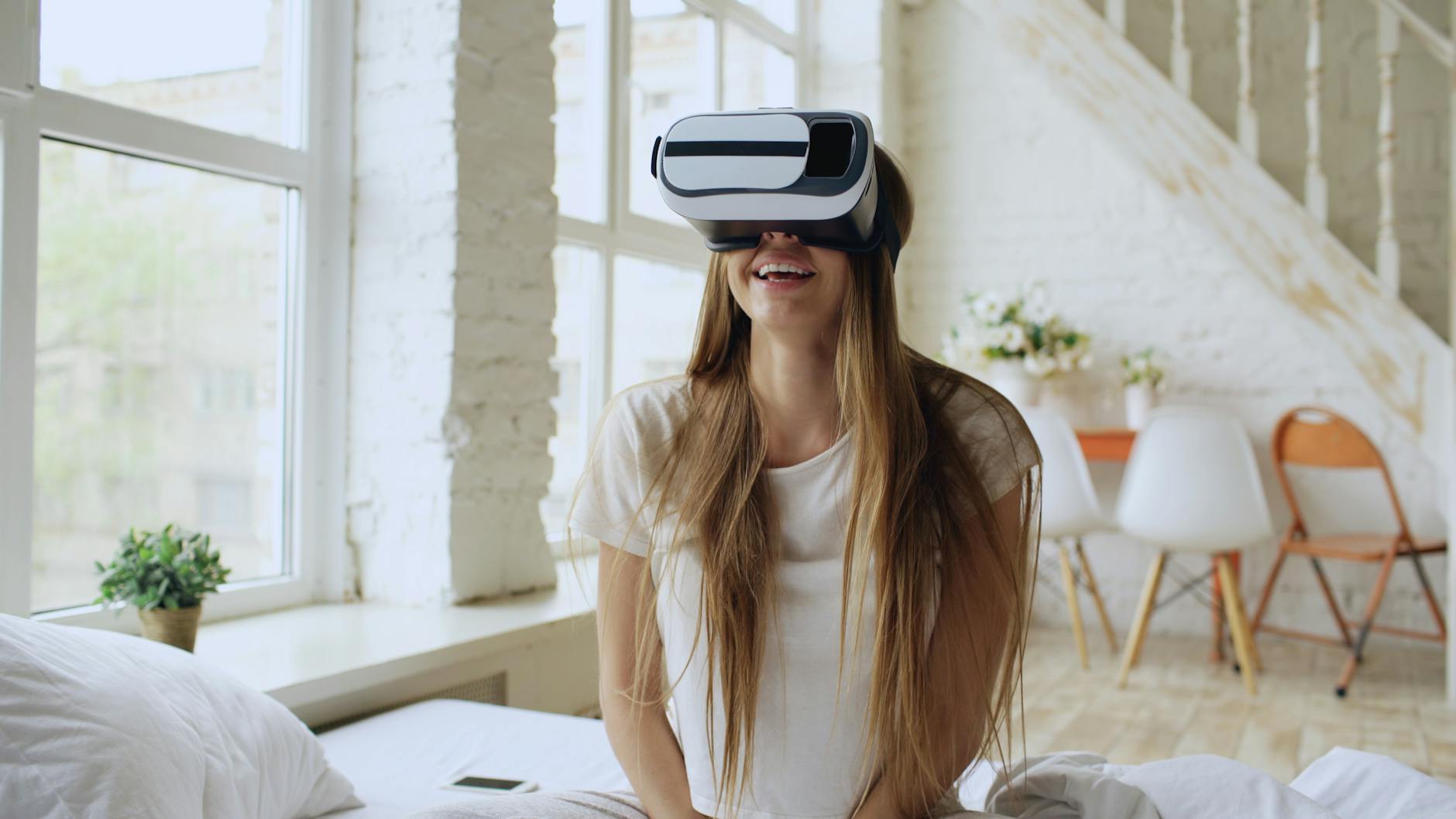 Junge Frau mit VR-Headset in einem hellen Loft, statt am echten Reiseziel