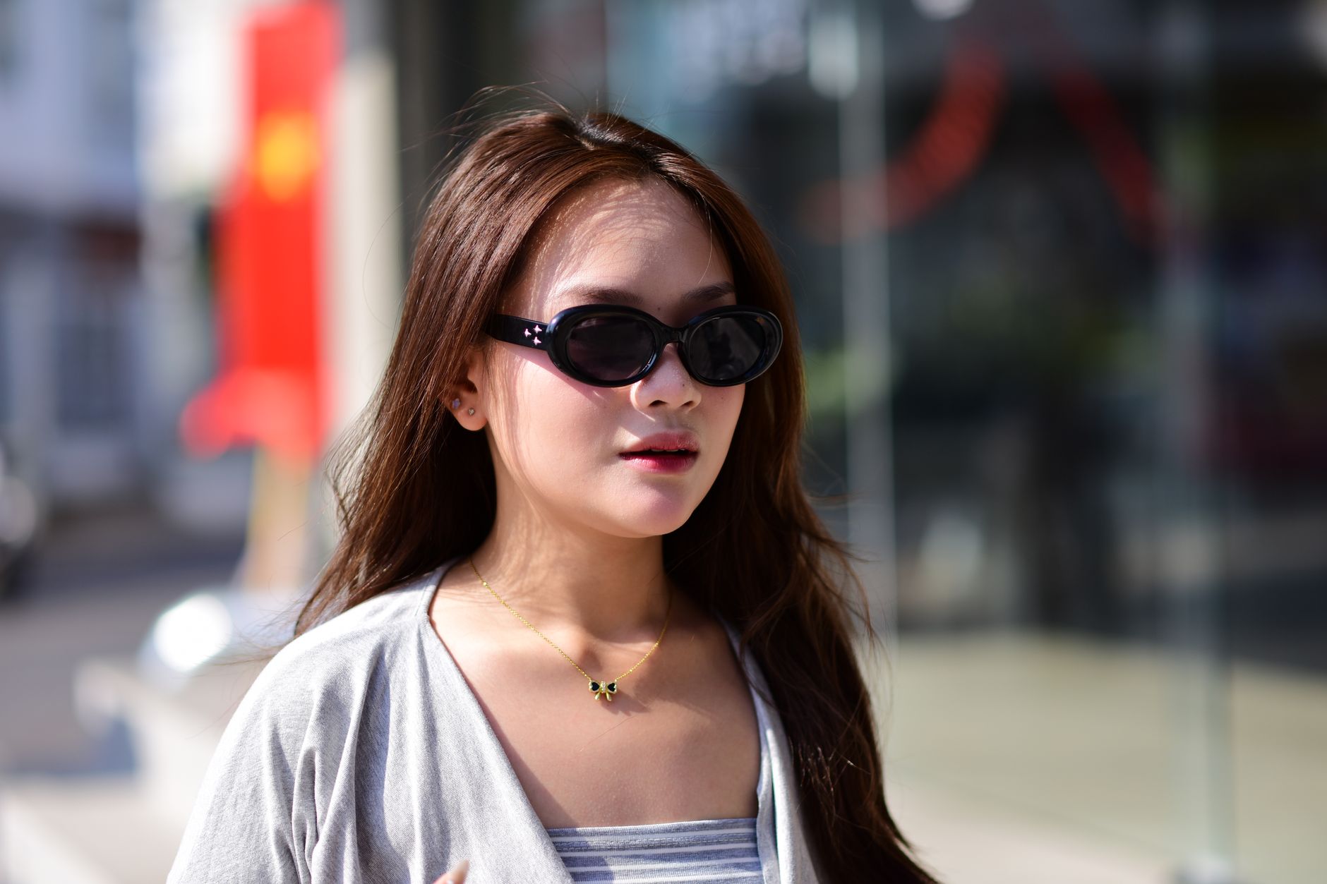 Woman with oversized sunglasses in sunlight, summer street-style