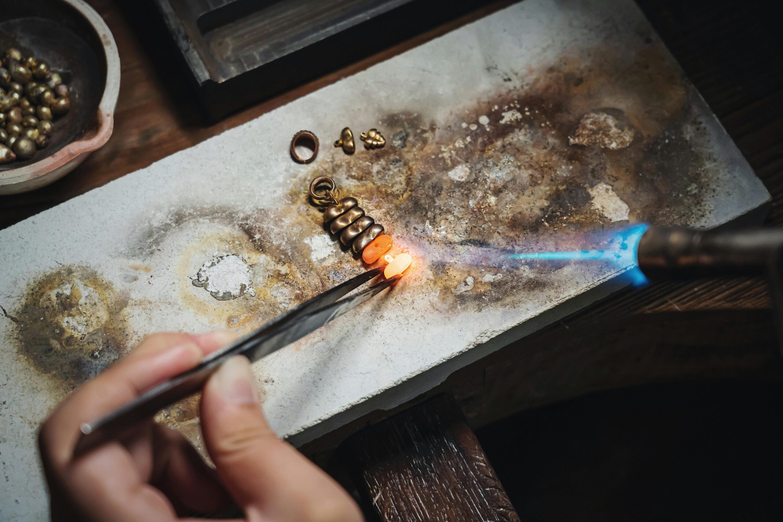 Goldschmiedin bearbeitet einen Ring aus Gold in der Werkstatt