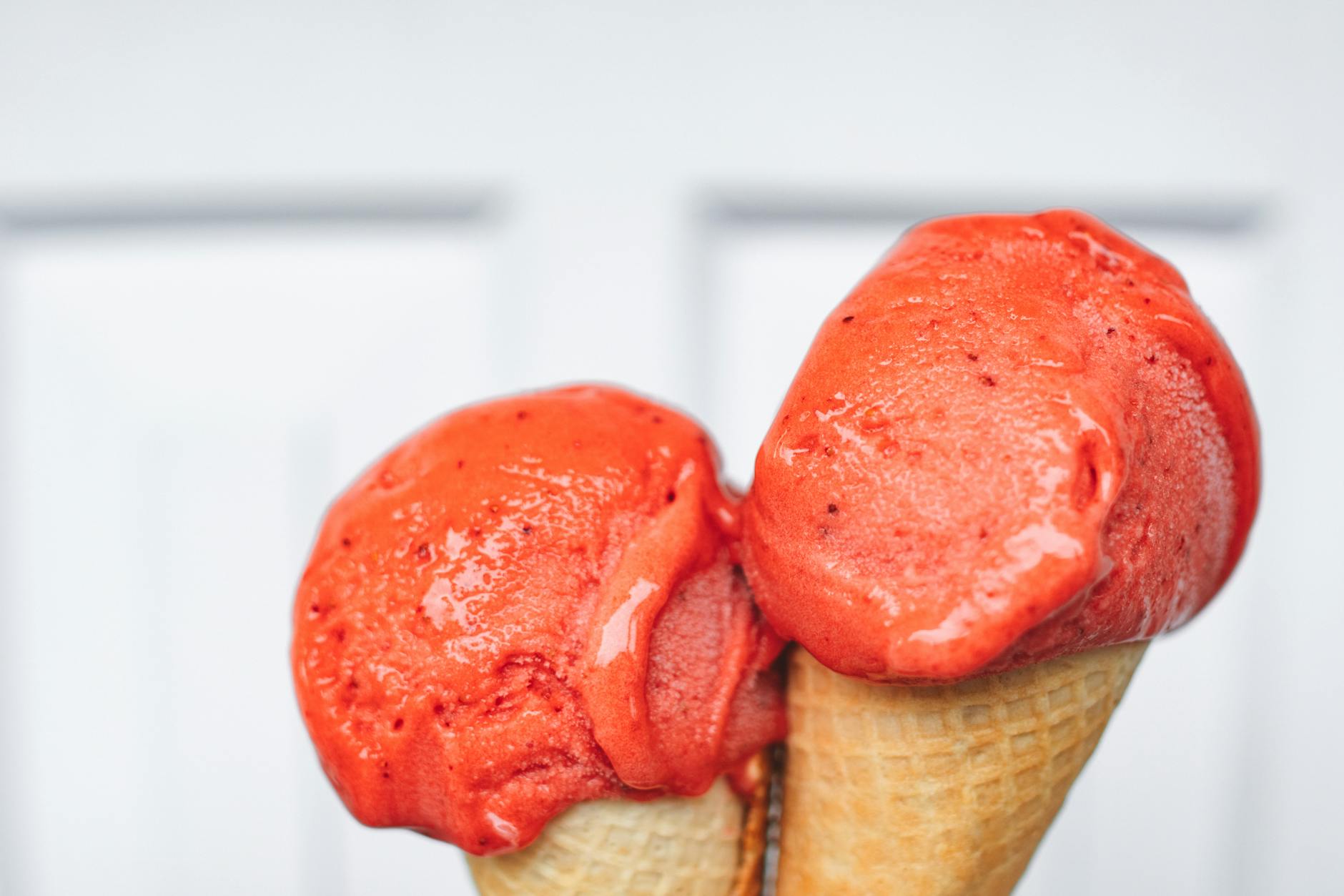 Delicious strawberry ice cream cones on a white background, perfect for summer dessert concepts.