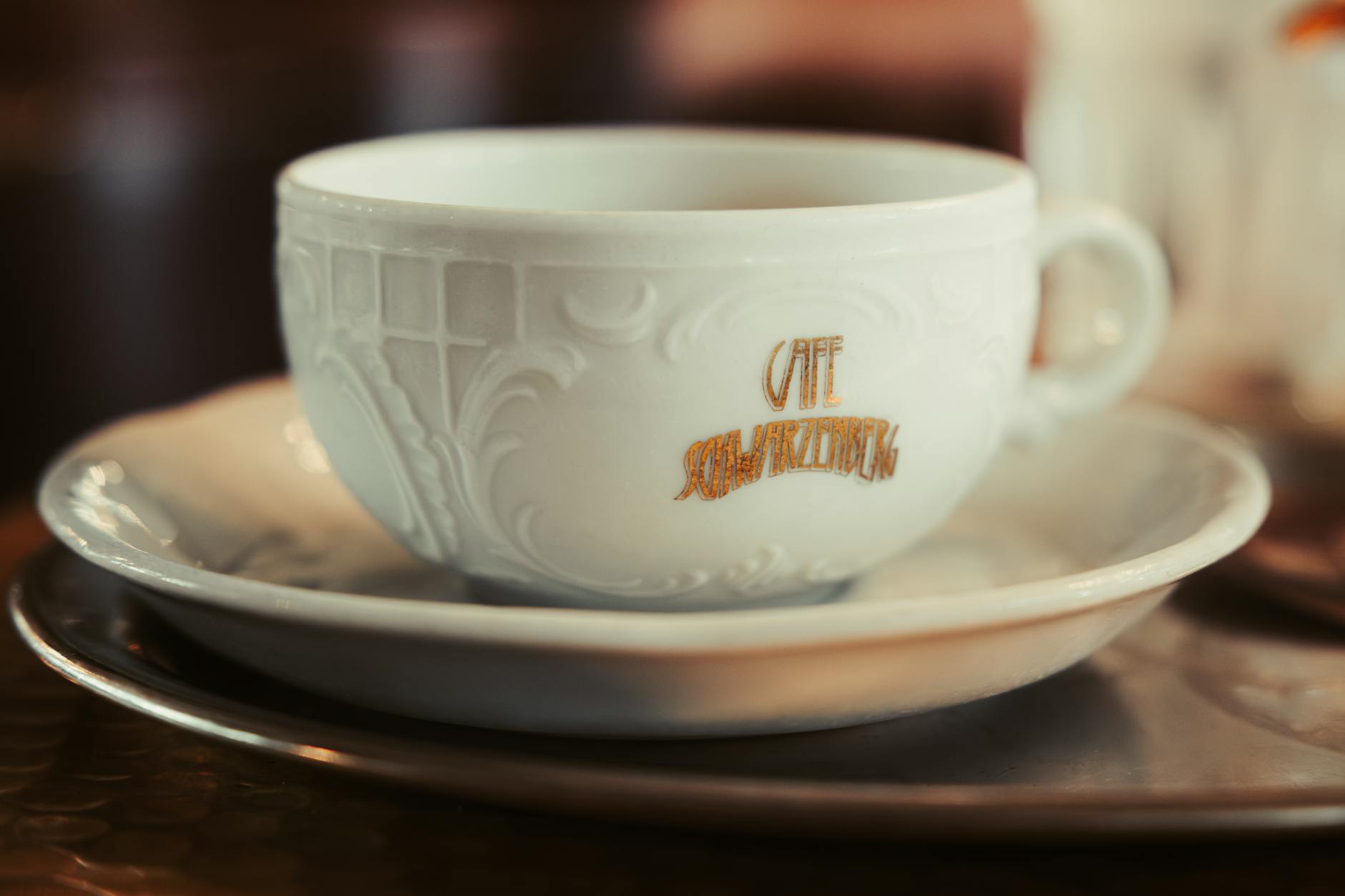 A close-up of a decorative coffee cup at Cafe Schwarzenberg, Vienna, encapsulating classic Viennese ambiance.