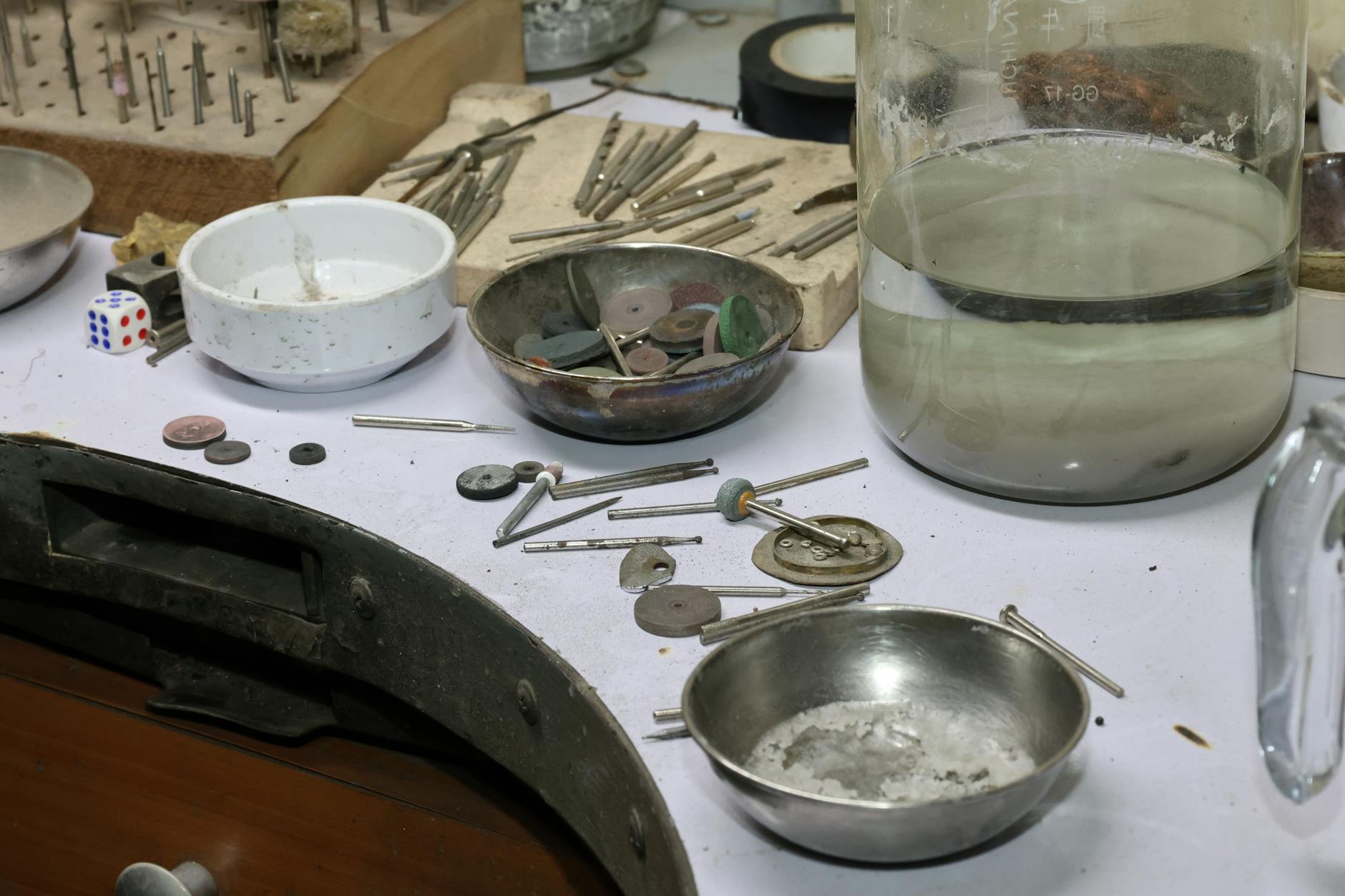 A detailed view of a jeweler's workbench with various tools and materials for crafting and repair.