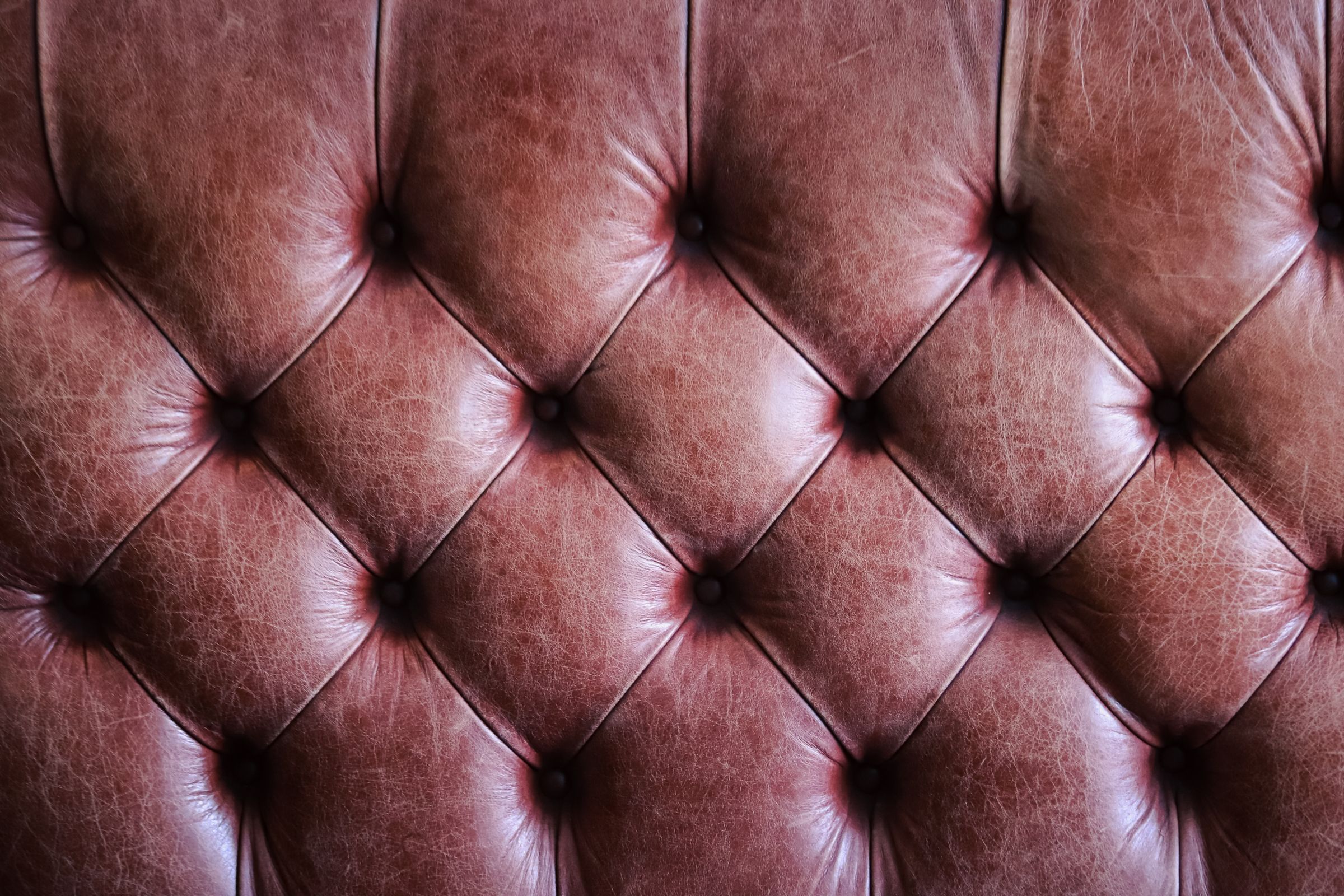 Patiniertes braunes Leder mit Knopfheftung als Materialdetail