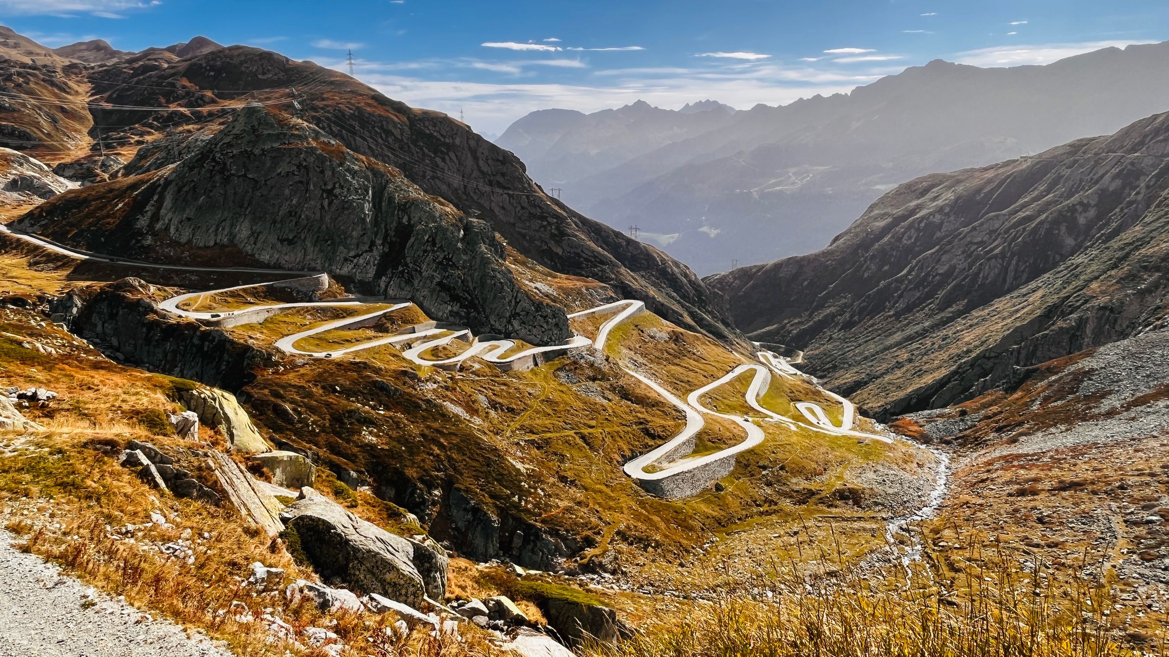 The ramp of the Stilfser Joch winds through autumn light down rocky slopes into the valley