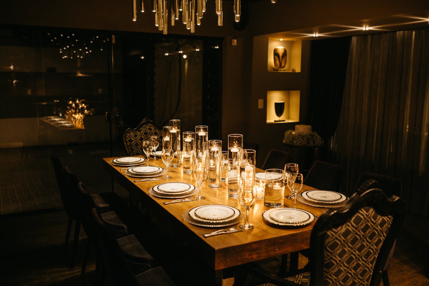 Elegant gedeckter Tisch in einem warm beleuchteten Speiseraum bei Kerzenlicht, gedämpfte Atmosphäre