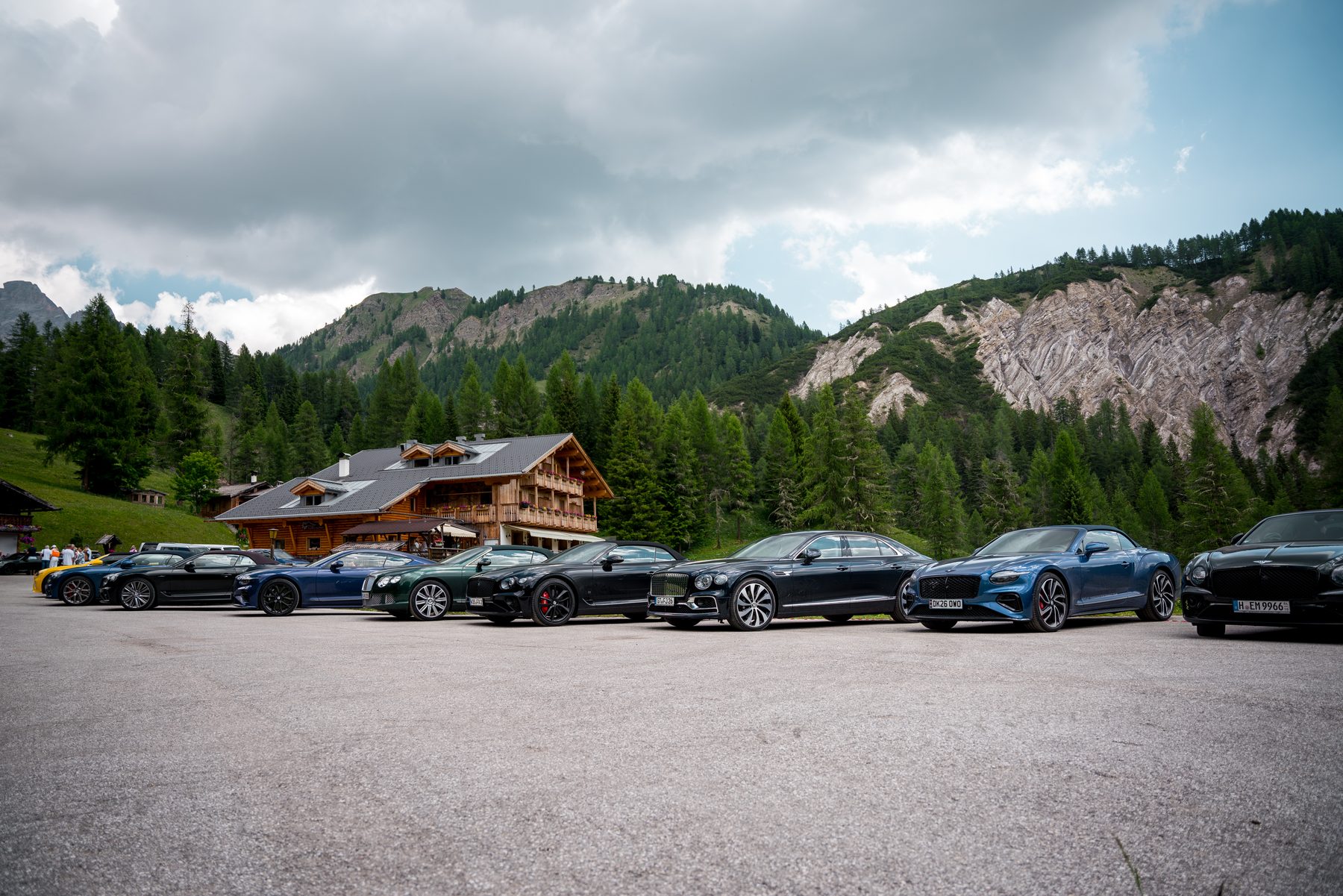 Bentleys parked outside Rifugio San Sebastiano with a striking rock summit behind