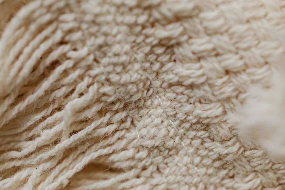 Nahaufnahme einer feinen Kaschmir-Masche in warmem Beige