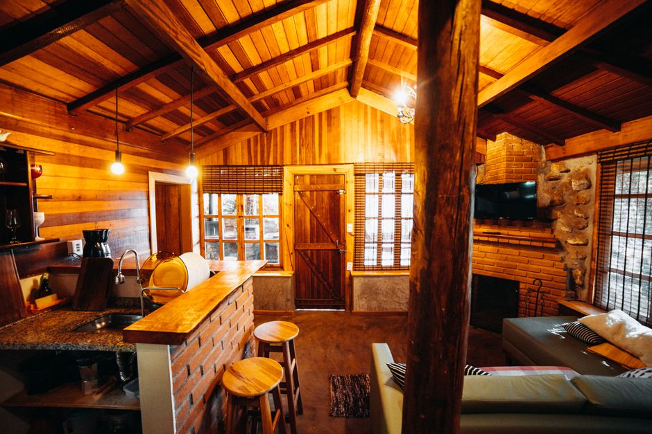 Warmer Wohnraum mit Holzgetäfel und offenem Kamin