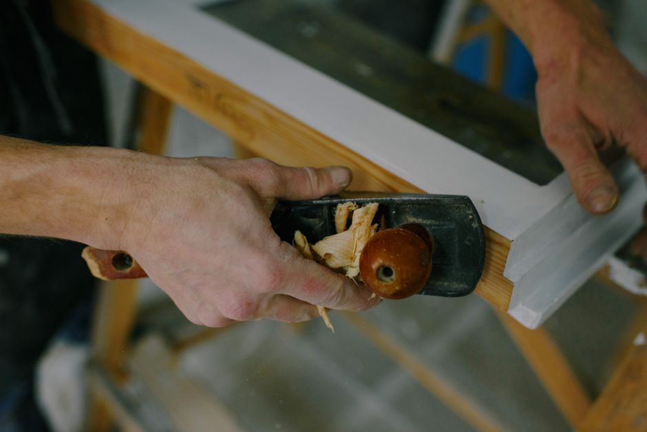 Craftsman planes wood in the workshop